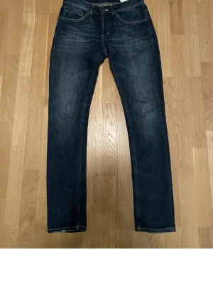 Mörkblå jeans från Nudie Jeans - Säljer ett par mörkblå jeans från Nudie Jeans med klassisk femficksmodell och raka ben. Jeansen har kontrastsömmar och är tillverkade i denim med snygg tvätt. Perfekta för dig som gillar stilrena och tidlösa jeans.