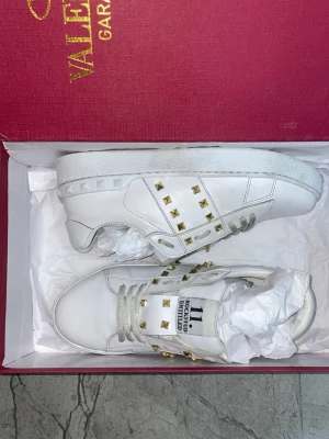 Valentino Rockstud vita sneakers - Hej, säljer dessa jätte snygga Valentino garavani i storlek 37.  ☺️ De är knappt använda. Perfekt för sommaren och alla dagar. Alla nitar är på. 🤝Rekommenderar dessa starkt. Jätte snygg på dig som vill se mer fräsch och sticka ut mer. Jätte snabb leverans ✨ Priset går självklart att diskutera. Bara skor medföljer vid köp. Vet ej om de är äkta 