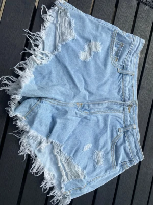Jeansshorts  - Korta shorts med hål och fransar 