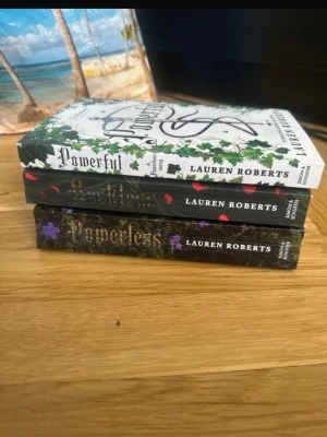 Powerful och Powerless av Lauren Roberts - Säljer tre böcker av Lauren Roberts: Powerful och två exemplar av Powerless. Omslagen har snygga illustrationer med blad, blommor och slingrande text. Perfekt för dig som gillar fantasy och spännande berättelser. Böckerna är i pocketformat och har färgstarka omslag.