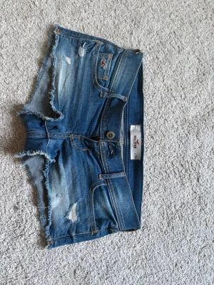 Hollister shorts  - Jättelågmidjade blåa jeansshorts från hollister med både dragkedja och knapp 🥰 Storlek 24 men har inga mått vad de motsvarar! 