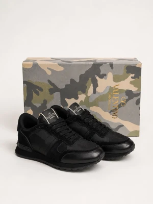 Svarta sneakers från Valentino - Snygga svarta sneakers från Valentino Garavani med coola nitar på hälen. Skorna är gjorda i en mix av mocka och läder, har små tecken på användning, svarta snören och en klassisk låg siluett. Perfekta för dig som vill ha en stilren och exklusiv look.