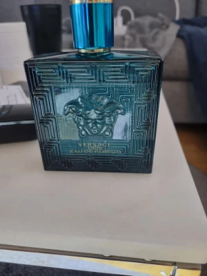Versace Eros Eau de Parfum 100ml - Säljer en lyxig parfym från Versace, Eros Eau de Parfum. Flaskan är fyrkantig i blått glas med guldiga detaljer och har ett Medusa-huvud i relief på framsidan. Designen är elegant och flaskan känns tung och exklusiv. Jag har öppnat flaskan men bara tagit max 5-6 sprutt men tydligen tål jag inte materialet eller själva lukten eller något jätte konstigt därför jag säljer den ny pris 950