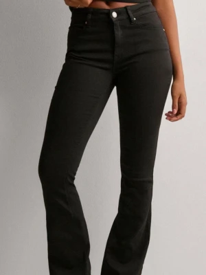 Svarta bootcut jeans med hög midja - Snygga svarta mid waist  bootcut jeans och  klassisk femficksmodell. Jeansen har en smickrande passform som sitter tajt över höfterna och låren och släpper ut nedtill. Perfekta till sneakers eller boots och lätta att styla till olika looks.