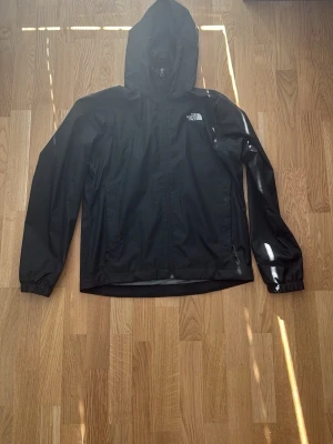 Svart regnjacka från The North Face - Snygg svart jacka från The North Face. Pris kan diskuteras. Helt oanvänd. Fick i present passar ej mig pågrund av att den är för stor.