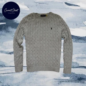 Grå kabelstickad tröja Polo Ralph Lauren - Snygg grå kabelstickad tröja från Polo Ralph Lauren med klassisk rund hals och svart broderad logga på bröstet | Size: S men passar M |