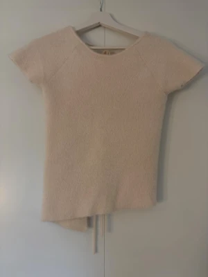 Fluffig tröja med öppen rygg - Säljer denna jättefina tröjan från Zara i storlek S. Den är kräm vit och lite fluffigt tyg. Tröjan är öppen i ryggen men har snören som man kan knyta och bestämma själv hur hårt man knyter dem. Det är ett litet hål på baksidan av tröjan men det är som en lös skåra så inget direkt hål. Annars är den i väldigt bra skick. Använd två gånger🥰🥰