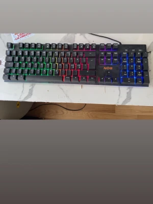 Gamingtangentbord  - Säljer ett NOS gamingtangentbord med RGB-belysning i flera färger och ett Tangentbordet har fullstor layout och svart plastchassi. perfekt för gaming eller streaming. 