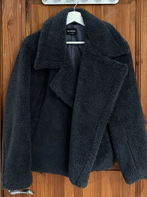 Mörkgrå teddyjacka  - Säljer en fluffig och oversized teddyjacka. Jackan har bred krage, långa ärmar och är gjord i mjukt teddy-material. Använd 1 gång 🐻💘 