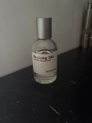 Pauling 19.0 extrait de parfum - Pauling 19.0 extrait de parfum från one bold chemist. Flaskan är genomskinlig med en enkel vit etikett och svart samt röd text. Parfymen har en stilren, rund form och ett matt silverfärgat lock. Perfekt för dig som gillar minimalistisk design.