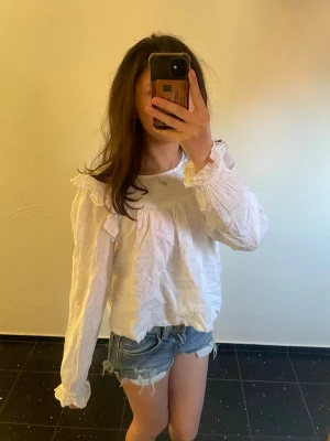 Vit blus med volangdetaljer - Söt vit blus med volangdetaljer längs axlarna och ärmsluten!💞Blusen är i storlek 158!!