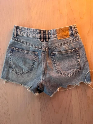 Jeansshorts - Säljer ett par ljusblå jeansshorts från Stradivarius med låg midja och vintageinspirerad tvätt. MISSA INTE fler jeans, jeansshorts och jeanskjolar till sommarn i min profil!!🍉👙💕🌴🌞