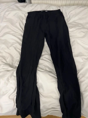 Svarta linnebyxor, lågmidjade  - Säljer ett par svarta linnebyxor med avslappnad passform och dragsko i midjan. Byxorna har raka ben och elastisk midja för extra komfort. De är inte för pösiga. Perfekta för en varm sommardag☀️