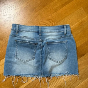 Kort jeanskjol - Mini/ kort jeans kjol med fransad kant nertill. Använd fåtalet gånger. I storlek M