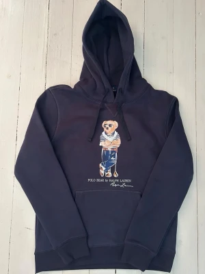 Ralph Lauren polo bear hoodie herr, storlek S  - Hej! Säljer denna riktigt schyssta polo bear hoodie från Ralph Lauren. Den är i storlek M men sitter en storlek litet och passar därför som en S. Den är endast använd någon enstaka gång och är därmed i ett nyskick. Original lappar och påse finns kvar och medföljer naturligtvis vid köp. Jag fraktar alltid snabbt! Mvh