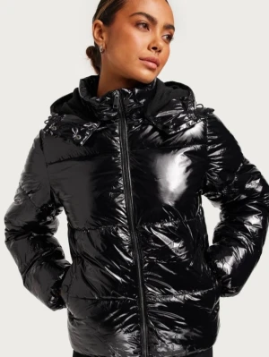  glansig jacka från Nelly  - Säljer en svart glansig pufferjacka med dragkedja framtill och stor huva. Jackan har quiltad design, två sidofickor och hög krage. Perfekt för kalla dagar när du vill hålla dig varm och samtidigt se stilren ut. Säljs inte längre 💕