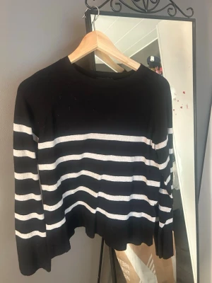 Svartvit randig stickad tröja PIECES - Säljer en svart stickad tröja från PIECES i storlek XS med vita horisontella ränder. Tröjan har rund halsringning, långa ärmar och en något lös passform. Perfekt för dig som gillar klassiska ränder och enkel stil.