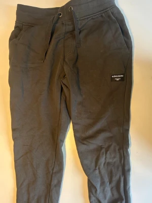 Svarta mjukisbyxor från Björn Borg - Snygga svarta mjukisbyxor från Björn Borg med dragsko i midjan och sidofickor. Byxorna har en klassisk passform och en diskret logga på vänster ben. Perfekta för chill dagar eller när du vill vara bekväm. Tillverkade i mjukt bomullsmaterial.