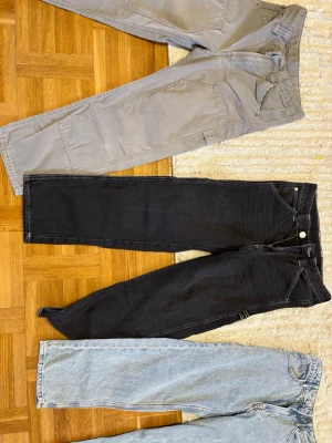 Svarta raka jeans med kontrastsömmar från HM till barn - Säljer ett par svarta jeans med raka ben och vita kontrastsömmar till barn från HM. Jeansen har klassisk femficksdesign och en extra ficka på sidan. Tillverkade i denim med en cool vintagekänsla. Perfekta för dig som gillar en avslappnad och trendig stil.