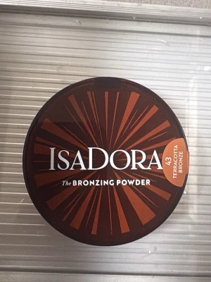 Isadora Bronzing Powder 43 Terracotta - Isadora The Bronzing Powder i nyansen 43 Terracotta Bronze. Kompakt bronzer i rund dosa med brunt och orange mönster på locket. Perfekt för att ge ansiktet en solkysst look med en varm, bronzig ton.
