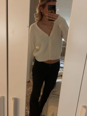 Vit ribbstickad kofta med knappar - Säljer en vit, ribbstickad kofta med v-ringning och stora knappar framtill från only. Använd fåtal gånger, inga defekter eller tecken på användning. Skriv om ni har frågor💕