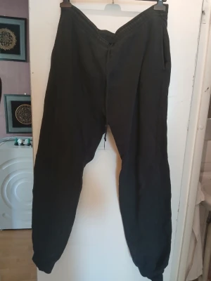 Svarta mjukisbyxor från Newbody - Svarta mjukisbyxor från Newbody med broderad logga på benet. Byxorna har resår i midjan och vid bensluten samt sidofickor. Perfekta för chill eller träning, tillverkade i mjukt och bekvämt material.