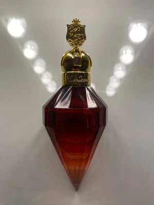 Katy Perry Killer Queen parfym - Unik parfymflaska från Katy Perry Killer Queen med en djup röd, diamantformad flaska och guldfärgat lock med dekorativ krona. Använd några få gånger. 