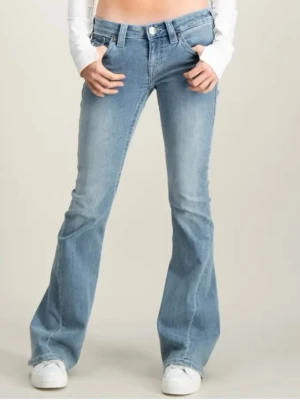 Ljusblå bootcut jeans från True Religion - Snygga ljusblå bootcut jeans från True Religion med klassiska kontrastsömmar och ikoniska fickdetaljer bak. Jeansen har låg midja, utsvängda ben och knappgylf. Perfekta för en avslappnad och trendig look.