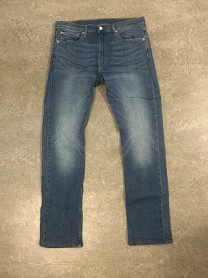 Blå levis 513 jeans - Blåa slim straight levis 513 jeans. Har använts en gång för att se storlek. Sitter som 34/32 då benen har kortats ner. Har fler av samma model i olika färger i min profil