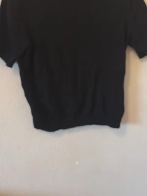 Svart kortärmad tröja från H&M  - En enkel svart tröja med korta ärmar och rund hals. Perfekt för en clean och stilren look. Passar bra till jeans eller kjol och är lätt att matcha med andra plagg. För mer frågor är det bara att dma💞