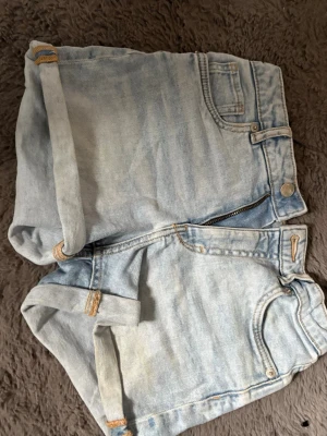 Ljusblå jeansshorts - Snygga ljusblå jeansshorts med uppvikta ben och klassiska fem fickor. Shortsen har dragkedja och knapp framtill. De är midwaist❣️