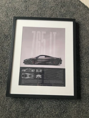 Inramad McLaren 765LT plansch - Snygg plansch med McLaren 765LT i svart, inramad med svart träram och vit passepartout. Bilden visar bilen från sidan samt tekniska ritningar och specifikationer. Perfekt för bilentusiasten som vill ha något unikt på väggen. Mått: 30*40cm. Ram ingår ej. 
