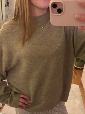 Beige mysig stickad tröja  - Mysig beige stickad tröja med rund hals och avslappnad passform. Använd fåtal gånger 
