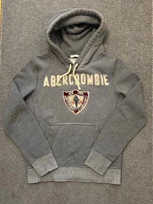 Vintage Abercrombie & Fitch Hoodie - Säljer denna as snygga Abercrombie & Fitch Hoodien | Mycket bra skick | Storlek M | Längd ≈ 70cm, Bredd armhåla-armhåla ≈ 58cm | Modell 175cm, 68kg | Hör av vid funderingar! 