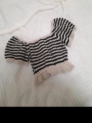 Svart beige randig stickad virkad topp sommar - Svart och beige randig knitted topp från Gina Tricot, storlek S, passar även XS Söt design vid axlarna♡ Lite kortare modell, använd endast en gång och i jättebra skick! Hör av dig vid frågor eller bud 💌 #trendig #sommar #söt #topp