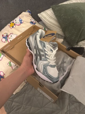 Asic gel kayano turkos/fjord grey helt nya - Snygga sneakers från ASICS i vitt och ljusgrått med meshpaneler och silvriga detaljer. Skorna har en chunky sula och klassisk snörning. Perfekta för dig som gillar sportig och trendig stil. Materialet är en mix av mesh och syntet.