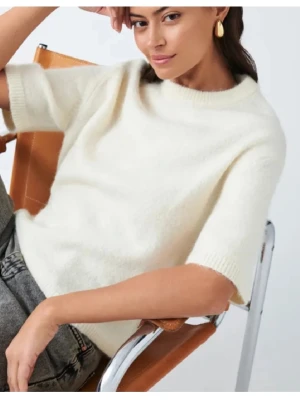 Vit stickad t-shirttröja - Vit stickad t-shirttröja med korta ärmar och rund hals. Tröjan har en avslappnad passform och är tillverkad i ett mjukt, fluffigt material som ger en mysig känsla. Perfekt att styla med jeans eller kjol för en trendig look. Använd 1-2 ggr, mycket bra skick! 