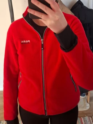 Peak Performance Fleecejacka - Säljer en röd Peak Performance fleecejacka i storlek M. Har du frågor angående mått eller vill ha fler bilder så är det bara att kontakta mig