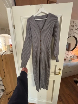 Adoore liknande klänning  - Lång, ribbad klänning i grått med v-ringning och långa ärmar. Perfekt att styla lager på lager nu till våren! Påminner om adoore!! Använd en julafton.
