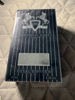 Parfums de Marly Layton 125ml - Lyxig parfym från Parfums de Marly, modellen Layton Royal Essence. Flaskan rymmer 125 ml och kommer i en elegant svart förpackning med silverdetaljer och klassisk logga. Perfekt för dig som gillar exklusiva dofter med stilren design.