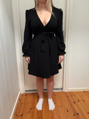 klänning  - en svart klänning med armar och vringing, STORLEK 38