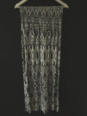 Svartvit långklänning med mönster - Mönstrad långklänning eller lång kjol i svart och vitt med elastisk smock upptill. Axelbandlös klänning.Klänningen har ett grafiskt, nästan boho-inspirerat mönster och är gjord i ett mjukt, lätt material som passar perfekt till varma dagar.