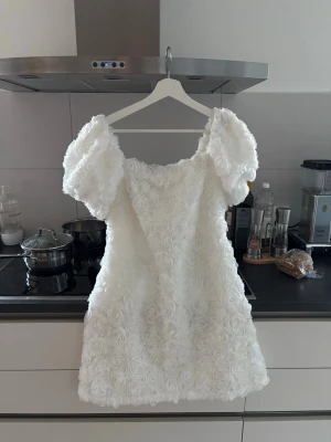 Studentklänning Vit kortklänning  - Så fin studentklänning från Ida Sjöstedt storlek 36, man kan ha den off shoulder ele med armarna uppe på axlarna.