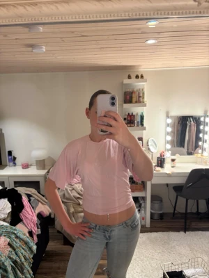 Ljusrosa croppad t-shirt - Säljer en ljusrosa croppad t-shirt med korta ärmar. Toppen har en enkel och avslappnad stil, perfekt att matcha med jeans eller kjol. Materialet känns mjukt och bekvämt mot huden.