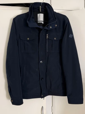 J.Lindeberg jacka - Säljer en riktigt snygg J.Lindeberg jacka i en snygg mörkblå färg. Mycket bra skick (se bilder)! Storlek S. Perfekt nu till våren! Hör av er🙌