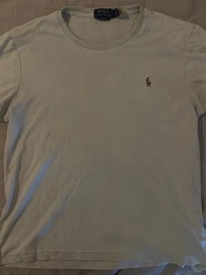 Vit t-shirt från Polo Ralph Lauren - Klassisk vit t-shirt från Polo Ralph Lauren med rund halsringning och det ikoniska broderade logotypen på bröstet. Tillverkad i mjuk bomull och har en normal passform. Perfekt basplagg för alla tillfällen.