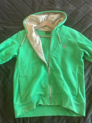 Grön hoodie med dragkedja - Fräsch grön hoodie från Paul Smith med dragkedja och grå insida på huvan. Skick 10/10, endast använd vid enstaka tillfällen 🙌🏻. Nypris 2000+, mitt pris 699. Perfekt för en avslappnad stil och enkel att matcha med jeans eller joggers. Kom dm vid frågor 🍾🤝