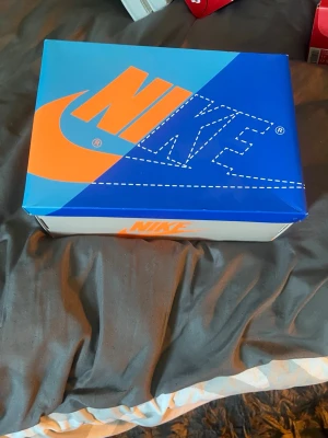 Det är ett par Nike air Jordan 1 dem är beage ljus blå svarta och blå och de finns extra skosnören som är orange svart vit  - Det är ett par knappt använde Nike air Jordan 1 använd kanske 3 gånger 