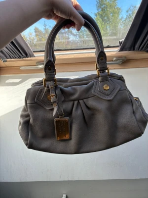 Marc Jacobs väska i taupe - Säljer denna super snygga Marc Jacobs väska i en kall taupe färg. Väskan är mycket bra skick! Skriv för frågor🥰