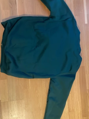 Mörkgrön hoodie från Polo Ralph Lauren - Snygg mörkgrön hoodie från Polo Ralph Lauren med dragkedja framtill och klassisk gul logga på bröstet. Hoodien har långa ärmar, fickor fram och är tillverkad i mjuk bomull. Perfekt för en chill och avslappnad stil.